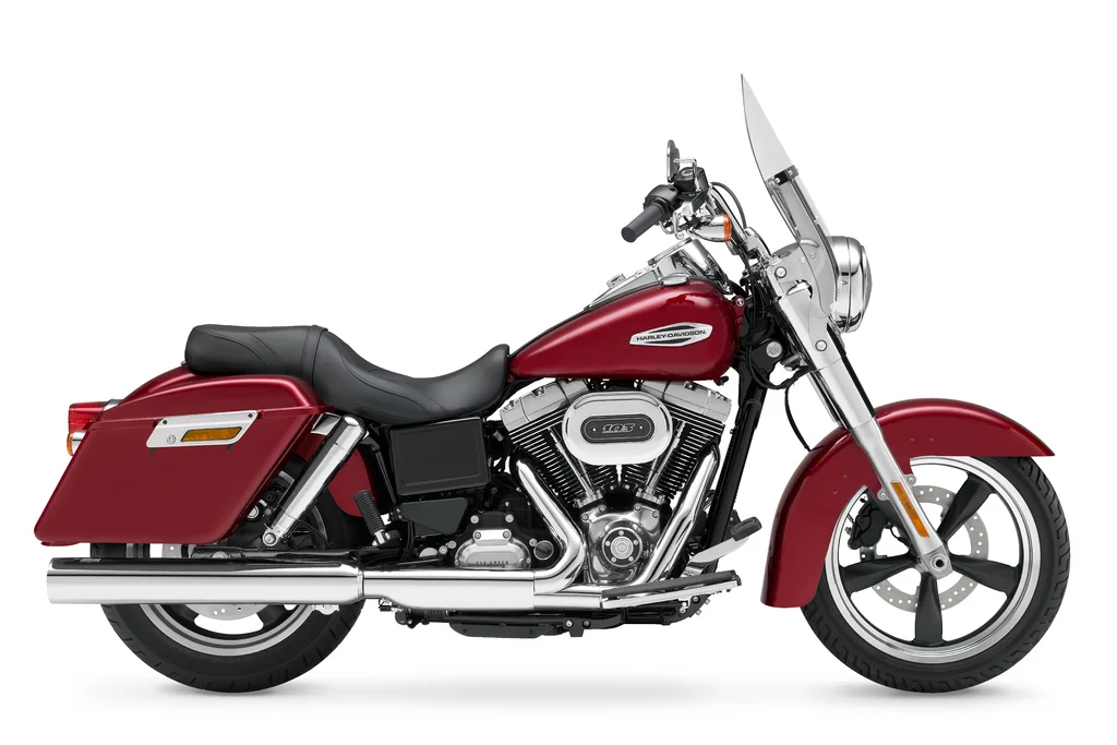 Right-side studio view of a red Harley-Davidson Switchback with windscreen, hard saddlebags and rider footboards.